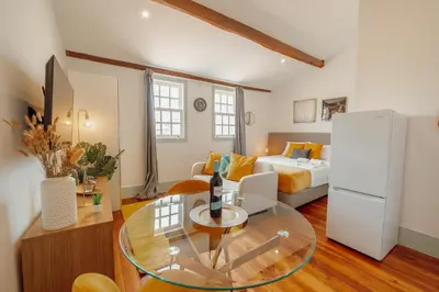 a living room with a bed and a glass table at Downtown Suites by Vacationy in Porto