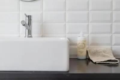 a bathroom counter with a sink and a bottle of soap at Casa B in Porto