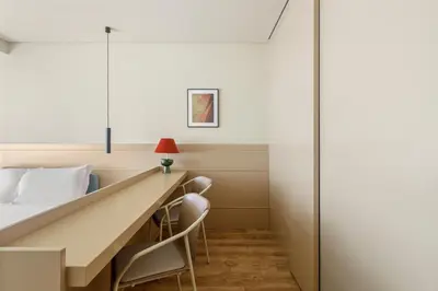 a bed room with a long desk and chairs at Pelicano in Porto