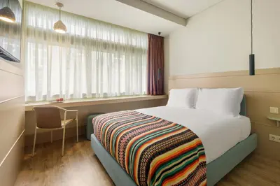 a bedroom with a bed with a colorful blanket on it at Pelicano in Porto