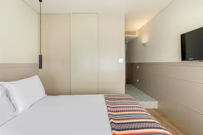 a bedroom with a white bed and a tv at Pelicano in Porto