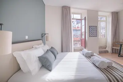 a white bed in a room with a window at VC Heritage Ribeira Porto in Porto