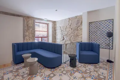 a living room with a blue couch and two chairs at VC Heritage Ribeira Porto in Porto