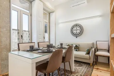 a white bedroom with a bed and a table at Beco do Paço by Porto Dream Stays in Porto