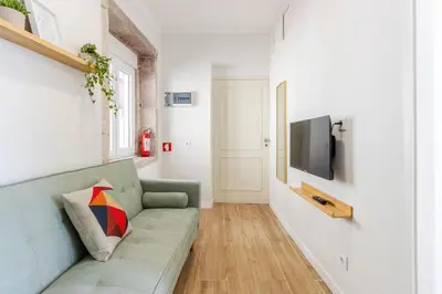 a living room with a couch and a tv at Porto Riverville Apartments in Porto