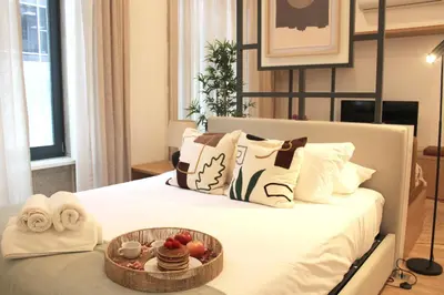 a bed with a bowl of fruit and a tray of food at Modern Flat Near Trindade by LovelyStay in Porto