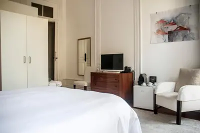 a bedroom with a bed and a tv and a chair at Oporto Loft in Porto
