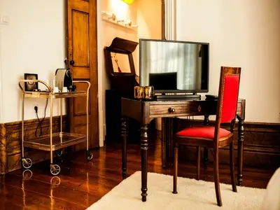 a room with a desk with a tv and a red chair at Oporto Loft in Porto