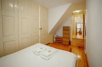 a bedroom with a white bed with two towels on it at Vintage Flat by Hosty in Porto