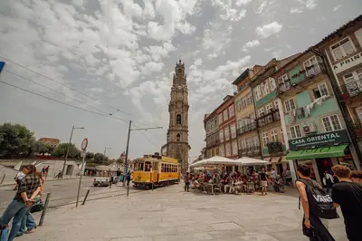 a yellow bus on a city street with a clock tower at Vintage Flat by Hosty in Porto