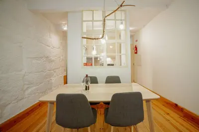 a dining room table with chairs and a bottle of wine at Vintage Flat by Hosty in Porto