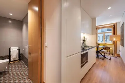 a kitchen with white walls and wooden floors at PortoPoint in Porto
