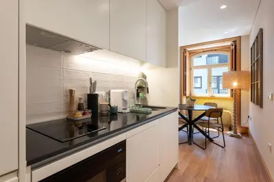 a kitchen with a black counter top and a table at PortoPoint in Porto