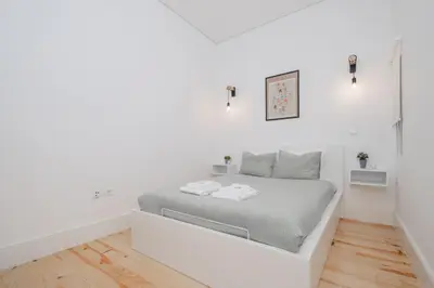a white bedroom with a bed in a room at Host Wise - Sunny Downtown Apartment in Porto