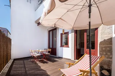 a patio with a table and chairs and an umbrella at Host Wise - Sunny Downtown Apartment in Porto