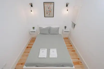 a bed in a small room with two slippers at Host Wise - Sunny Downtown Apartment in Porto