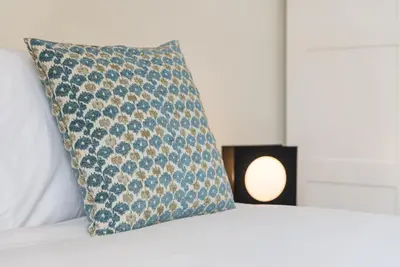 a pillow sitting on top of a bed with a candle at GuestReady - Cosy getaway in Porto in Vila Nova de Gaia