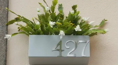 a white plaque with a flower arrangement on a wall at GuestReady - Catorze de Outubro Houses 427 in Vila Nova de Gaia