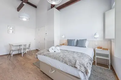 a white bedroom with a bed and a desk at GuestReady - Port Studio 1 in Vila Nova de Gaia