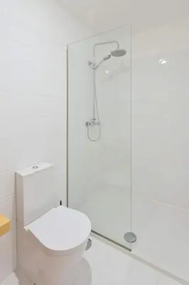 a bathroom with a toilet and a glass shower at GuestReady - Climbing Loft in Porto