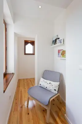 a white room with a chair and a window at GuestReady - Climbing Loft in Porto