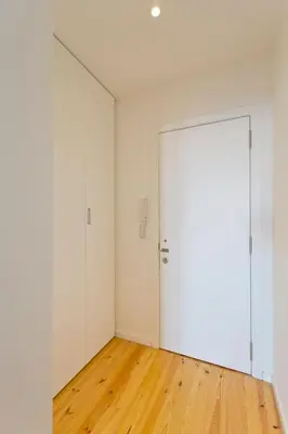 an empty room with a white door and wooden floors at GuestReady - Climbing Loft in Porto