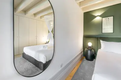 a bedroom with a mirror next to a bed at GuestReady - Loft 515 in Porto