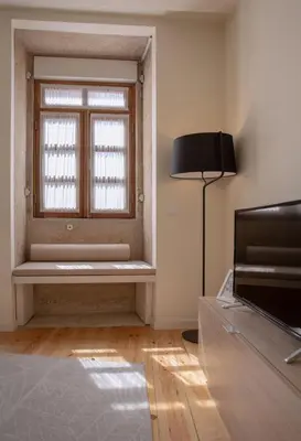 a room with a window with a bench and a lamp at GuestReady - Catorze de Outubro Houses - 387 in Vila Nova de Gaia
