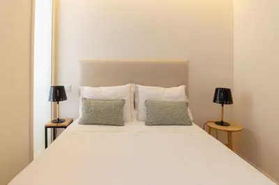 a bedroom with a white bed with two lamps at GuestReady - Catorze de Outubro Houses - 387 in Vila Nova de Gaia