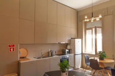 a kitchen with white cabinets and a table with chairs at dvnest - Premium 1BR Apartment with River View! in Porto
