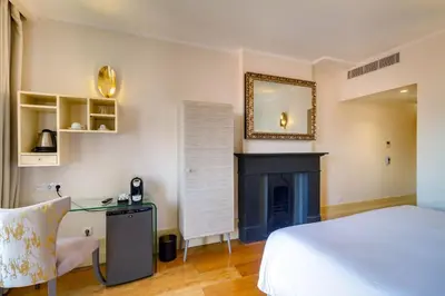 a bedroom with a bed and a desk and a fireplace at Oca Flores Hotel Boutique in Porto