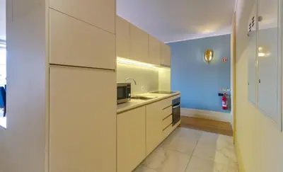 a kitchen with white cabinets and a sink at Oca Flores Hotel Boutique in Porto