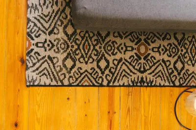 a black and white rug next to a wooden floor at Studio Faria Guimarães in Porto