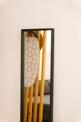 a mirror with a reflection of a wooden chair at Studio Faria Guimarães in Porto