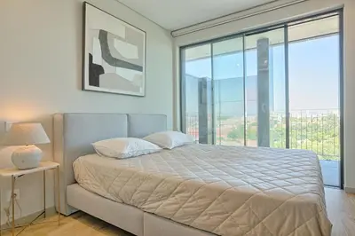 a bedroom with a bed and a large window at Brand New Luxurious Ap T2 - Amazing View- with garage in Vila Nova de Gaia