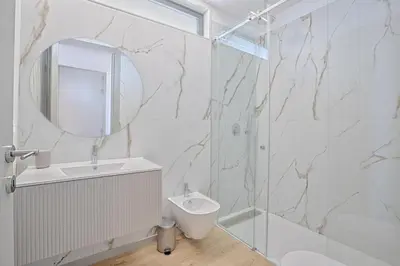 a bathroom with a shower and a sink and a mirror at Brand New Luxurious Ap T2 - Amazing View- with garage in Vila Nova de Gaia