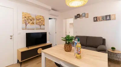 a living room with a table with a television and a couch at Stop & Relax - Parking in Porto