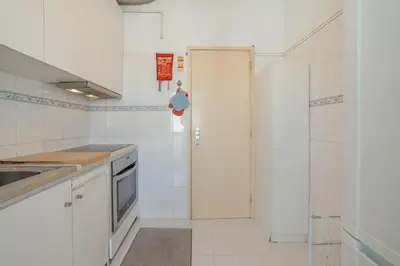 a white kitchen with a door to a shower at Downtown Classic With Terrace by Vacationy in Porto