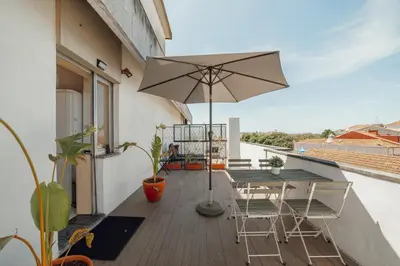a balcony with an umbrella and a table and chairs at Downtown Classic With Terrace by Vacationy in Porto