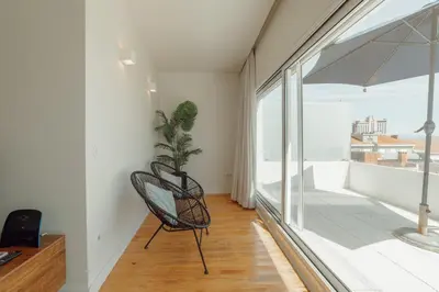 a room with a chair and a balcony at Porto Panoramic Views With Terrace by Vacationy in Porto