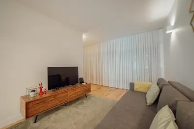 a living room with a couch and a flat screen tv at Porto Panoramic Views With Terrace by Vacationy in Porto