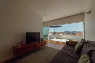 a living room with a couch and a flat screen tv at Porto Panoramic Views With Terrace by Vacationy in Porto