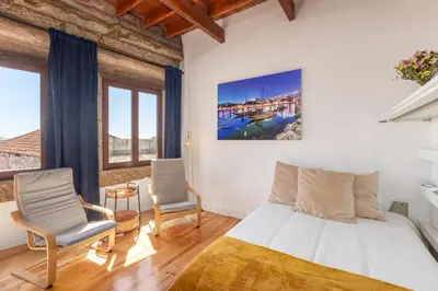 a bedroom with a bed and two chairs at Studio para 4 pessoas no Porto in Porto