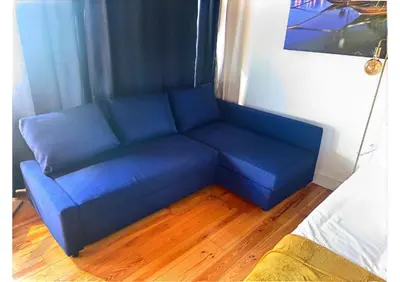 a blue couch in the corner of a room at Studio para 4 pessoas no Porto in Porto