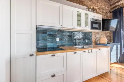 a kitchen with white cabinets and a sink at Studio para 4 pessoas no Porto in Porto