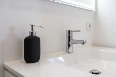 a black soap dispenser sitting on a bathroom sink at Studio para 4 pessoas no Porto in Porto