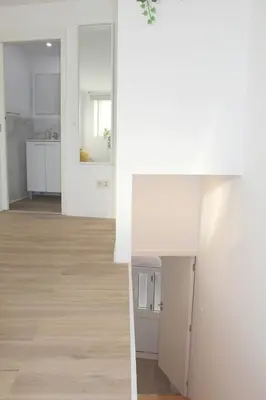 a living room and kitchen with white walls and wood floors at Oporto Nura Studio Downtown in Porto