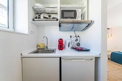 a small kitchen with a sink and a microwave at Oporto Nura Studio Downtown in Porto