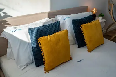 four pillows on a bed with white and yellow pillows at Oporto Nura Studio Downtown in Porto