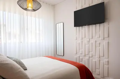 a bedroom with a bed and a tv on a wall at C&P Bolhão Downtown Studio in Porto